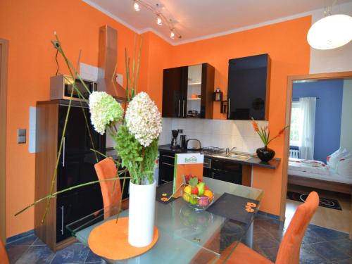 a vase of flowers on a glass table in a kitchen at Charming Forest Escape for Two in Langewiesen