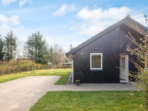a black house with a driveway in front of it at 6 person holiday home in Oksbøl-By Traum in Oksbøl