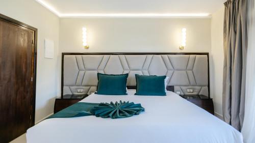 a bedroom with a large white bed with blue pillows at Hotel Prestige Agadir Boutique & SPA in Agadir