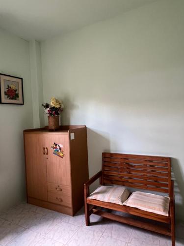 a room with a wooden bed and a cabinet at PhimHomeStayCR in Ban Thung Ngio