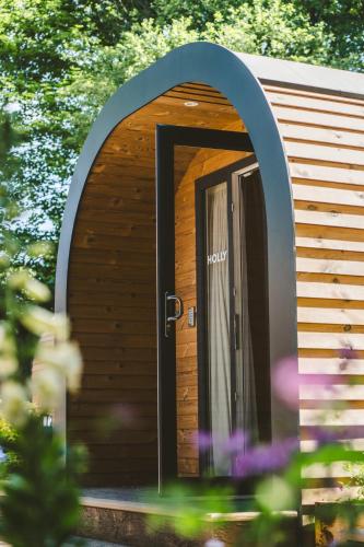 a wooden door in a circular mirror in front of a building at Moddershall Oaks Country Spa Retreat in Stone