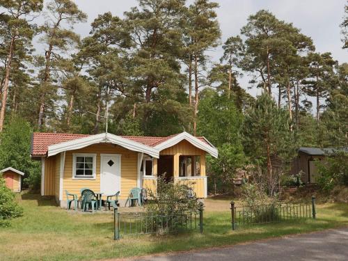 a small yellow house with a table and chairs at 5 person holiday home in MELLBYSTRAND-By Traum in Mellbystrand