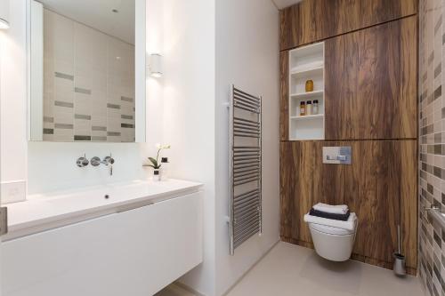 La salle de bains est pourvue d'un lavabo, de toilettes et d'un miroir. dans l'établissement Urban Chic - Chiltern & Baker, à Londres