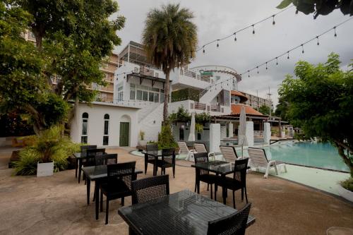 a patio with tables and chairs next to a pool at My Way Hua Hin Music Hotel SHA Extra Plus in Hua Hin