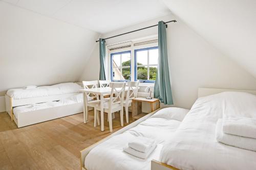 ein Schlafzimmer mit einem Bett und einem Tisch und Stühlen in der Unterkunft Vakantiepark Schoorlse Duinen in Schoorl