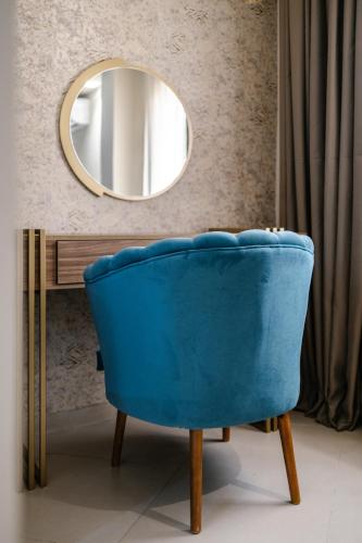 a blue chair in a room with a mirror at Hotel Prestige Agadir Boutique & SPA in Agadir