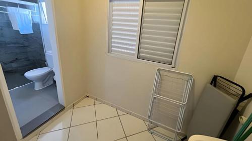 a small bathroom with a toilet and a window at Studio kitnet Apartamento Privativo Jundiai 08 in Ermida