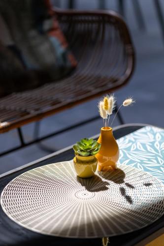 a table with a yellow vase with flowers on it at Holiday Inn Express Mechelen City Centre by IHG in Mechelen