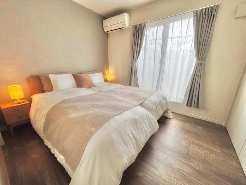 a bedroom with a large bed and a window at VJ House in Fukuoka