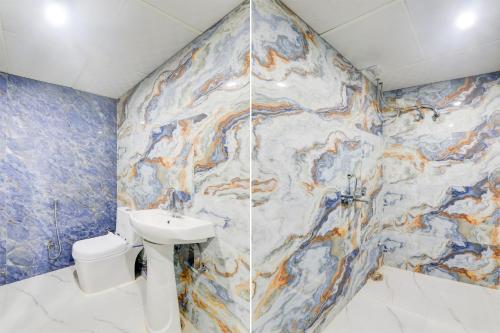 a bathroom with a sink and a mosaic wall at Hotel O Star Inn Hotel in Lucknow
