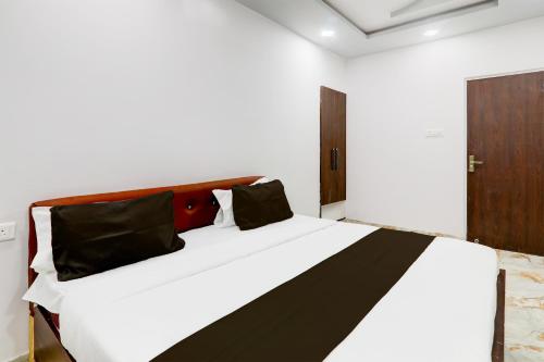 a bedroom with a large white bed with black pillows at Hotel O Star Inn Hotel in Lucknow