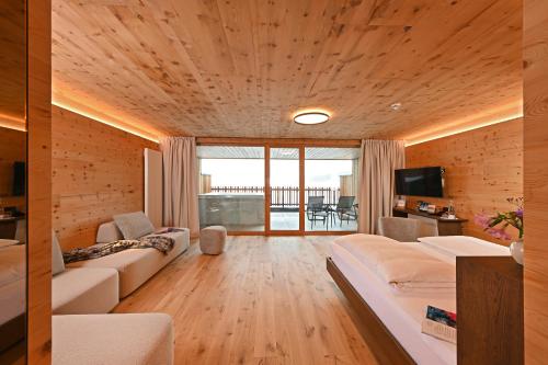 a living room with a couch and a television at Tratterhof Mountain Sky Hotel in Maranza