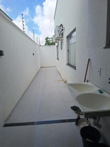 a bathroom with a sink and a tiled floor at Casa de 3 quartos a 500mts da praia do Araçagy Para até 10 pessoas in São Luís