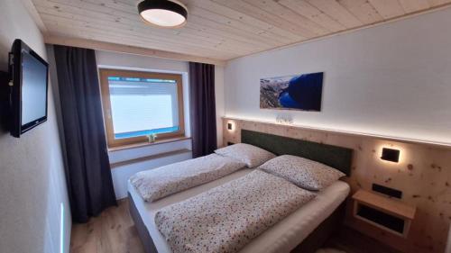 a small bedroom with a bed and a window at Haus Panorama in Gerlosberg