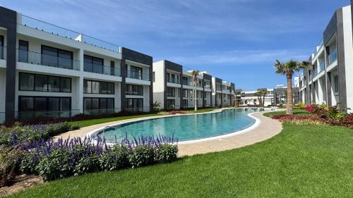 a swimming pool in front of a building at Luxurious 1 bedroom duplex apartment in Palmera Resort in Ayios Yeoryios