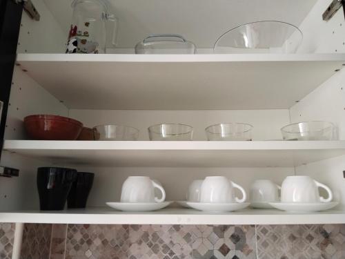 ein Regal mit Schalen und anderen Geschirr in einer Küche in der Unterkunft Piso vacacional en Sanlúcar in Sanlúcar de Barrameda