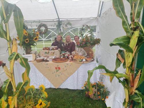 three women sitting at a table in a white tent at Gospodarstwo Agroturystyczne Bogdanówka in Rossosz