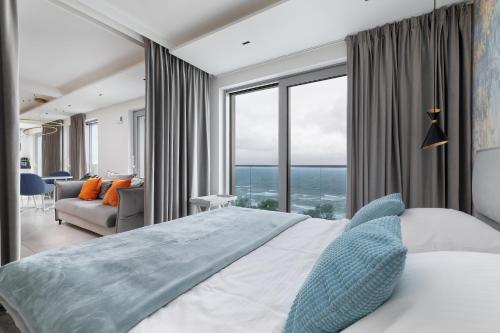 a bedroom with a large bed with a large window at Balticus by Solarento in Międzyzdroje