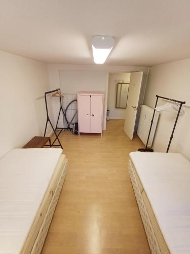 two beds in a room with wooden floors at Central Apartment close to the Marina in Aalborg