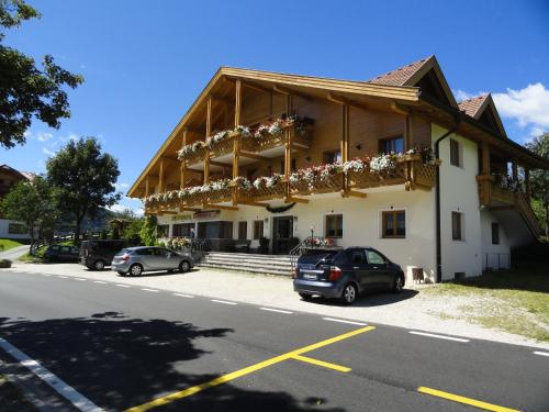 a building with cars parked in front of it at Pension Panorama in Monguelfo