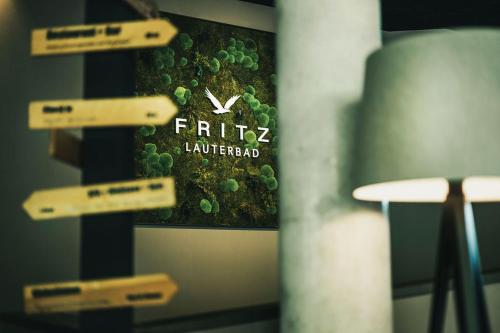 a sign on a wall with a picture of green plants at Fritz Lauterbad in Freudenstadt