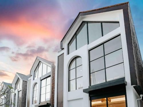 two white buildings with windows against a cloudy sky at Coco Villas 3 in Cemagi