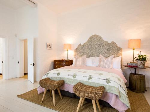 a bedroom with a large bed with two chairs at White House Koringberg in Koringberg