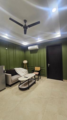 a living room with a couch and a ceiling fan at One Stayz by Zipcode in Gurgaon