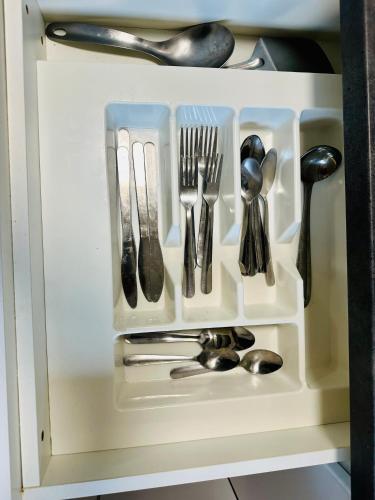a drawer with silver utensils in a cabinet at Second Home in Melbourne