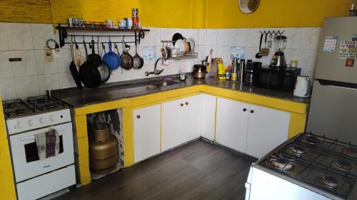 a kitchen with yellow walls and white cabinets and a stove at Casa Copada in Montevideo