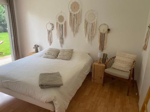 a bedroom with a bed and a chair and clocks on the wall at La Pignada 33170 in Gradignan