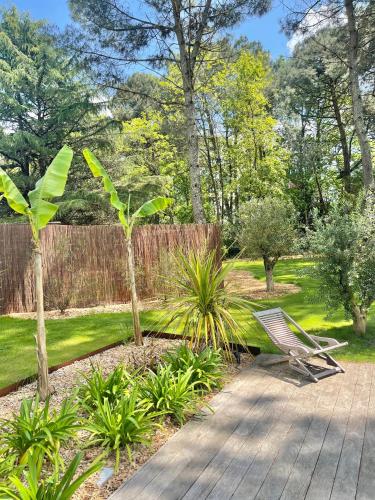 a garden with a bench and a fence at La Pignada 33170 in Gradignan