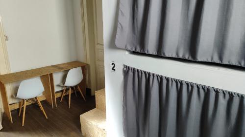 a room with two white chairs and a curtain at Casa Copada in Montevideo
