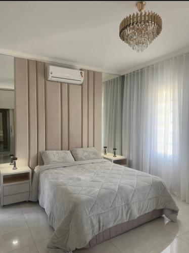 ein Schlafzimmer mit einem großen Bett und einem Kronleuchter in der Unterkunft Mansão Primavera com 03 quartos e piscina aquecida in Brasilia