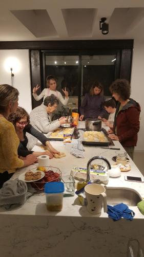 a group of people standing around a table with food at Modern Jem in Jerusalem in Geʼullim