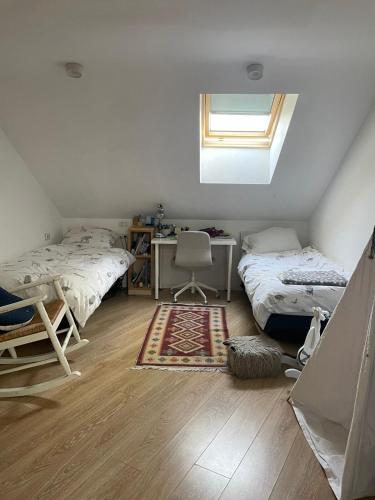 a bedroom with two beds and a desk and a window at Modern Jem in Jerusalem in Geʼullim