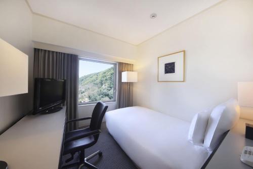 a hotel room with a bed and a window at ANA Crowne Plaza Kobe by IHG in Kobe