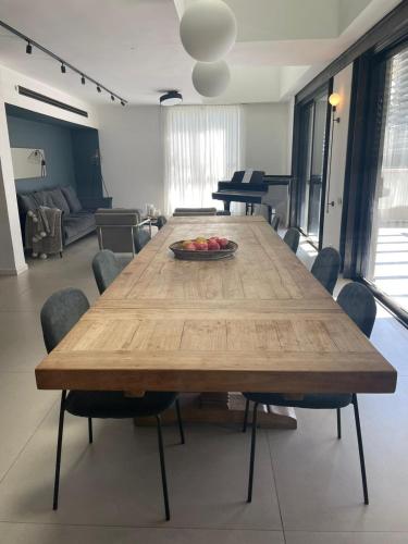 a wooden table with a bowl of fruit on it in a living room at Modern Jem in Jerusalem in Geʼullim