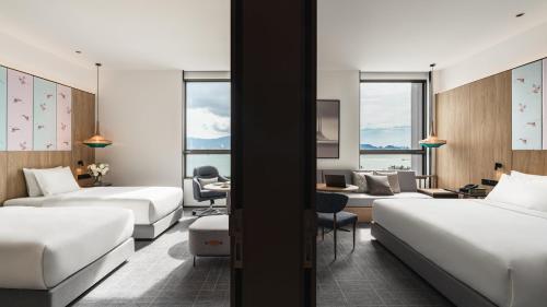 a hotel room with two beds and a desk at Crowne Plaza Penang Straits City by IHG in Perai