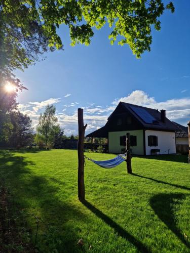a hammock in a field next to a house at Łap Las Pelnik in Pelnik