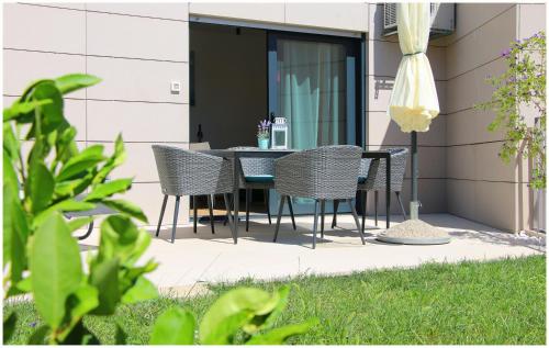 a patio with a black table and chairs at Royal Primošten in Primošten