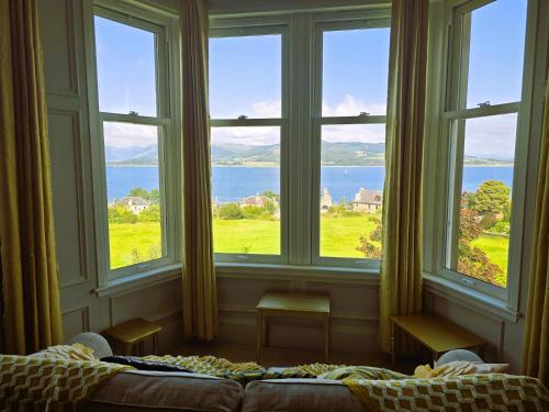 a bedroom with a large window with a view of the ocean at Bella Vista Manor - with elevated views over Rothesay & Loch Striven in Rothesay