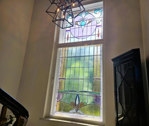 a stained glass window in a stair case at Bella Vista Manor - with elevated views over Rothesay & Loch Striven in Rothesay