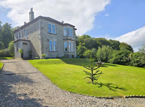 a large house with a grassy yard in front of it at Bella Vista Manor - with elevated views over Rothesay & Loch Striven in Rothesay