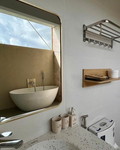 a bathroom with a large mirror and a sink at Minh Hai Resort in Phú Mỹ