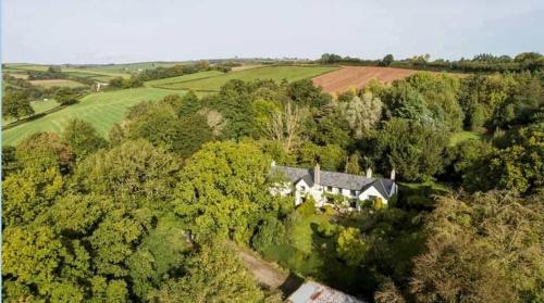 an aerial view of a house in the forest at West Wing Lurley Manor in Washfield