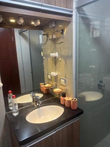 a bathroom with two sinks and a glass shower at Condominio Irala in Santa Cruz de la Sierra