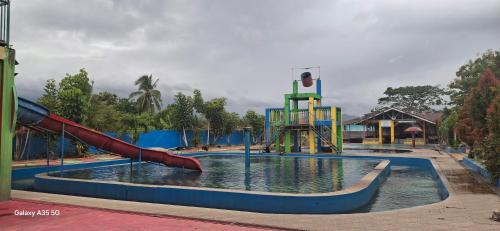 a water park with a slide in the water at sahati homestay and swimingpool in Payakumbuh