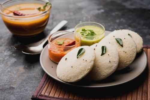 a plate of food with three sandwiches and a drink at Collection O Janappanchatram in Chennai