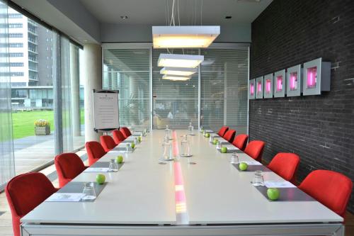 a long table with red chairs in a conference room at Garner Hotel Maastricht by IHG in Maastricht